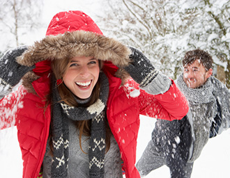 Young couple having snowball fight