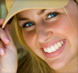 Blonde girl wearing a hat sought aesthetic dentistry near Highlands Ranch.