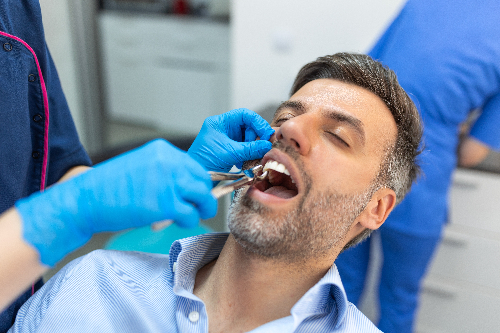 man having a tooth pulled in Denver