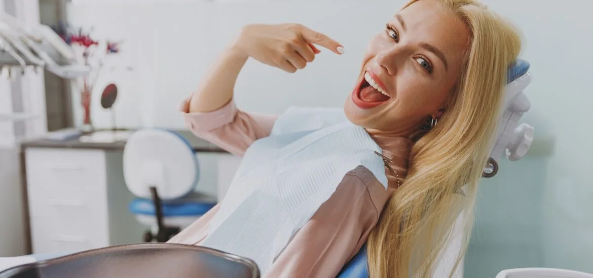 Calm woman covered by napkin point index finger on perfect smile.