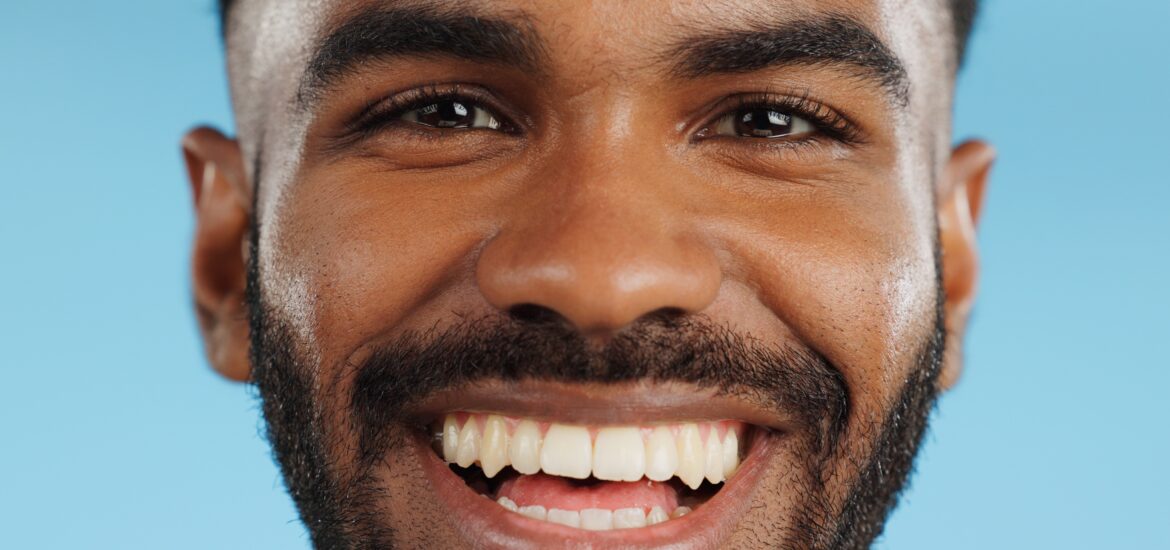 close-up of a happy man smiling against a blue background
