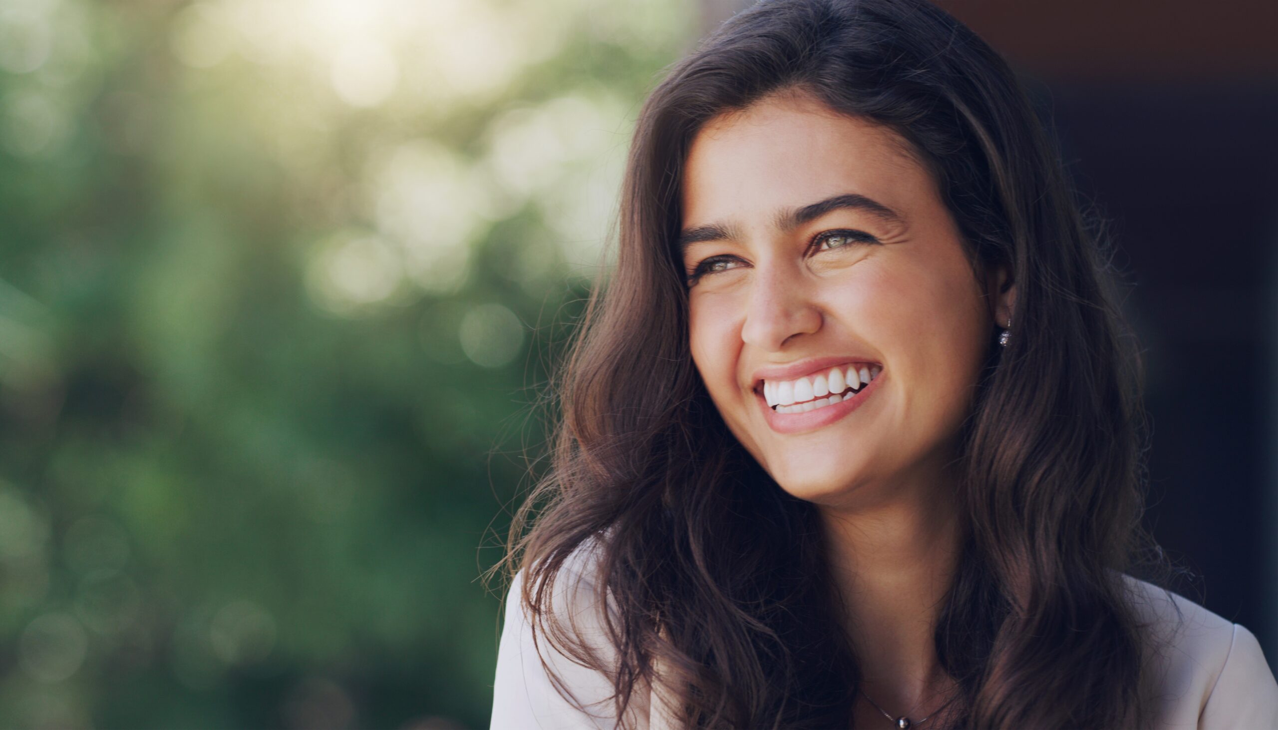 happy young woman smiling confidently outdoors
