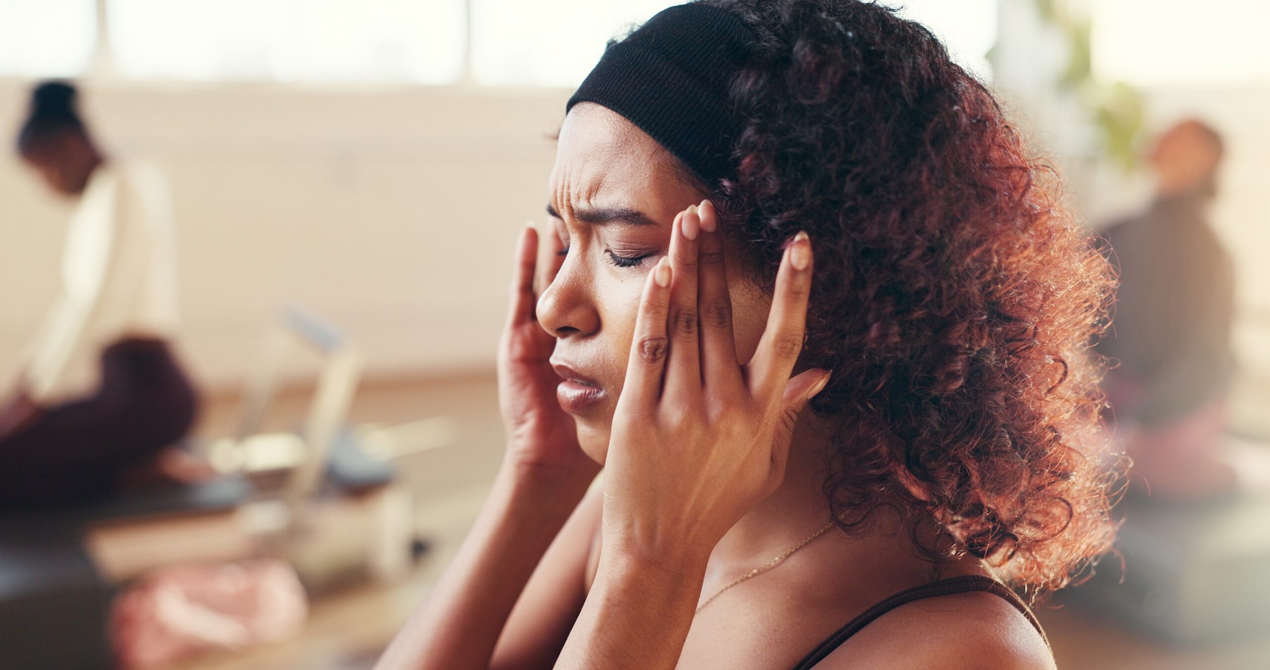 woman rubbing her temples, tension headache